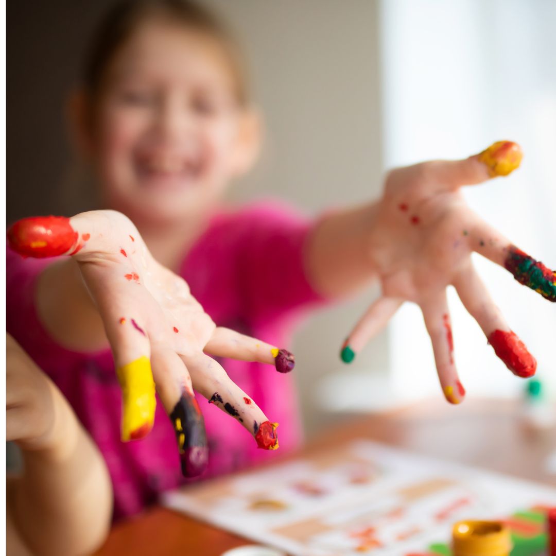young girl with paint on hands